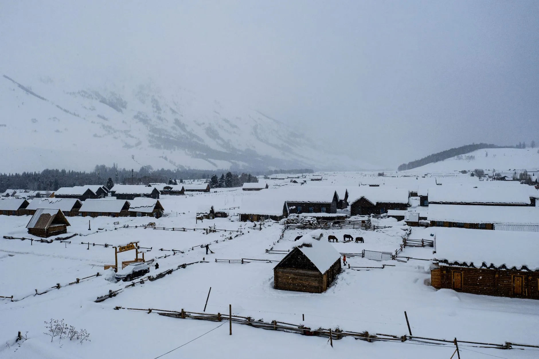 Aerial view of a snow-covered village ringed by mountains in northern China