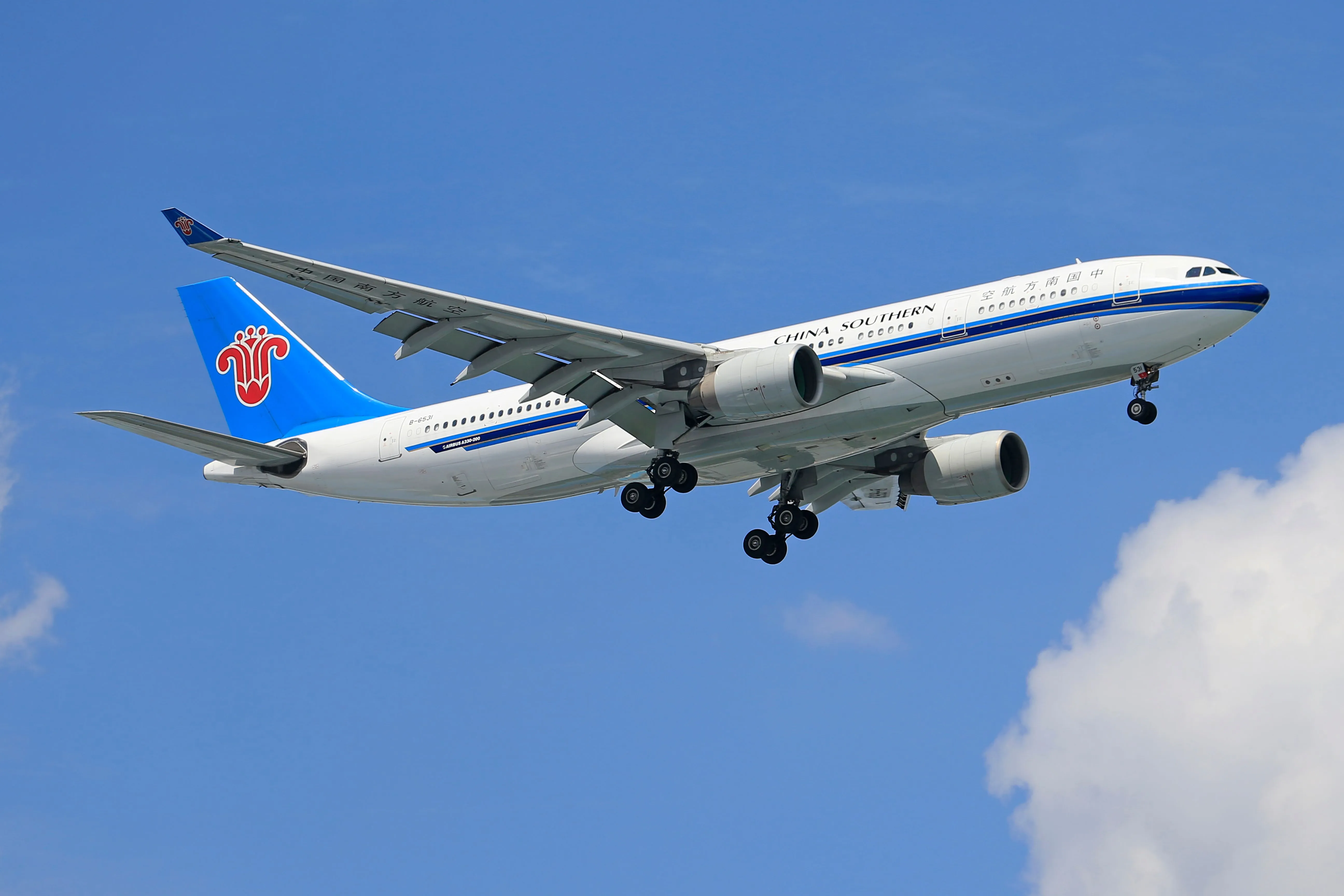 A China Southern Airlines Airbus A330 in flight against a clear blue sky
