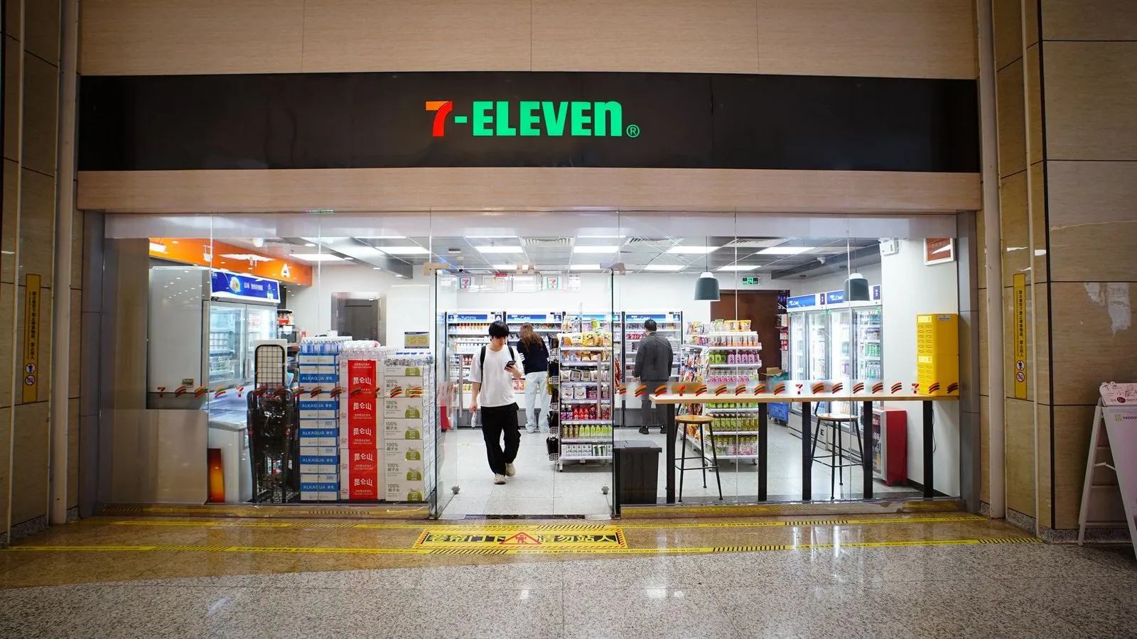 A convenience store interior with drinks coolers and hot food counter