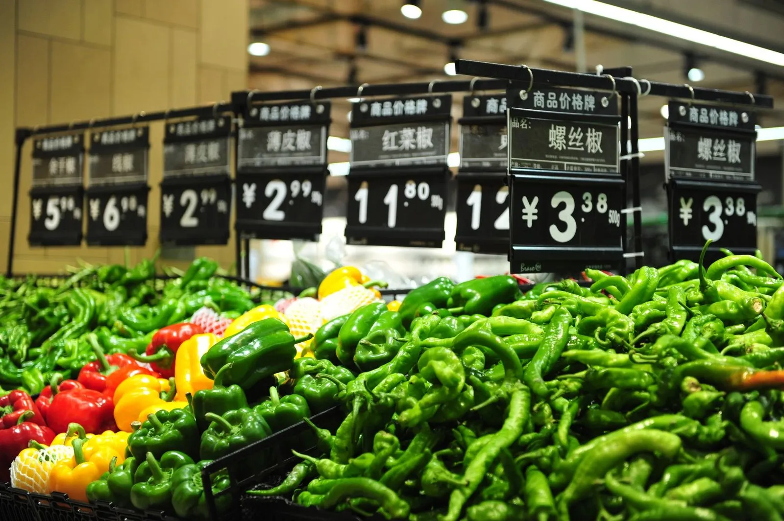 A supermarket produce section in China with Chinese price tags and yuan signs