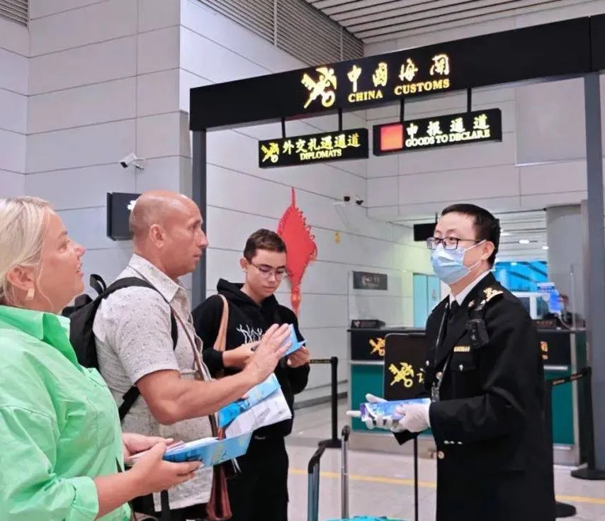 Airport customs officers inspecting arriving passengers' luggage