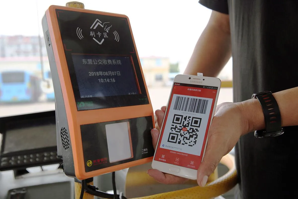 Scanning a phone to pay on a city bus in China